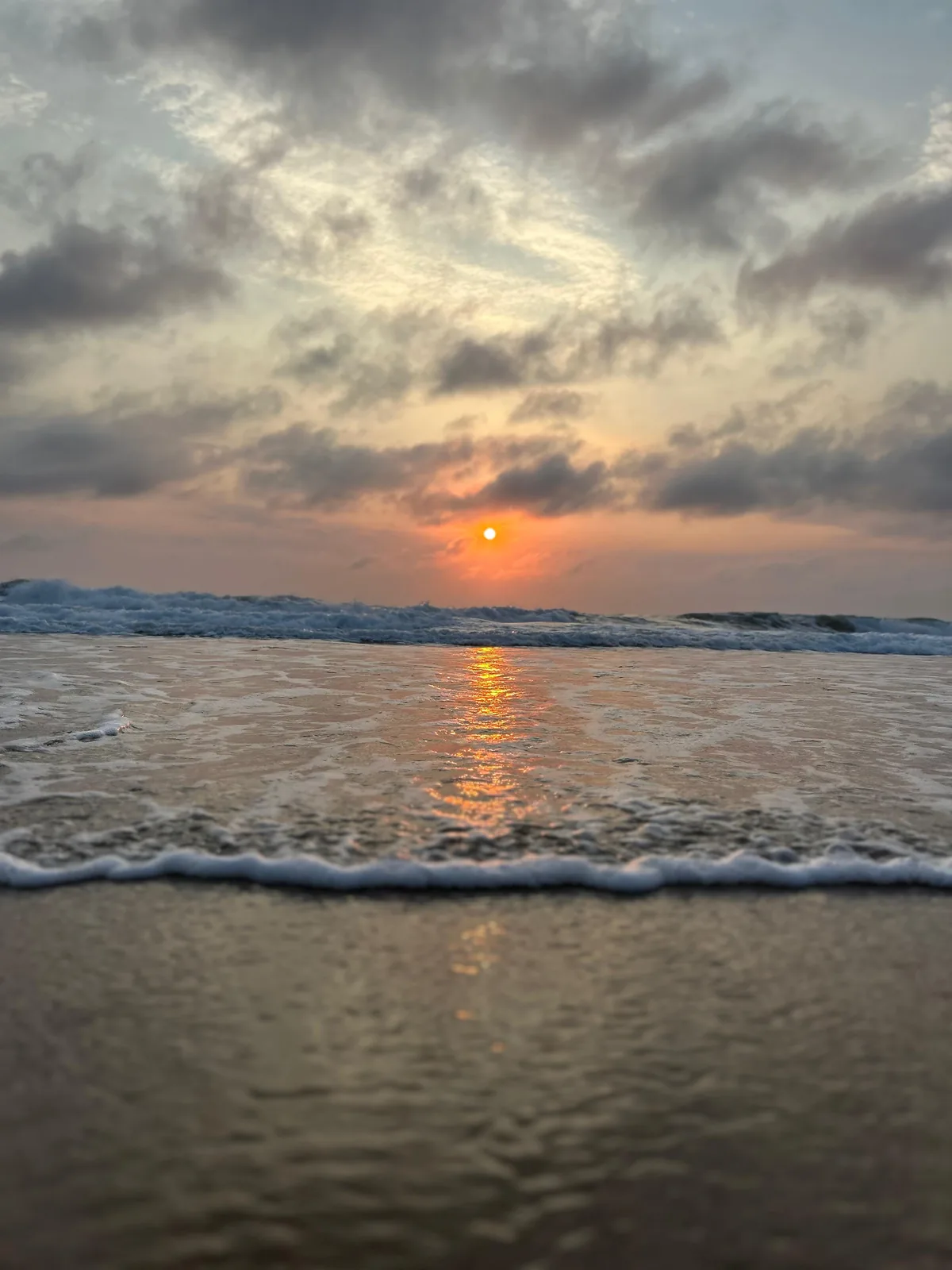 Sunrise over the ocean with a low horizon and reflected light across the water.